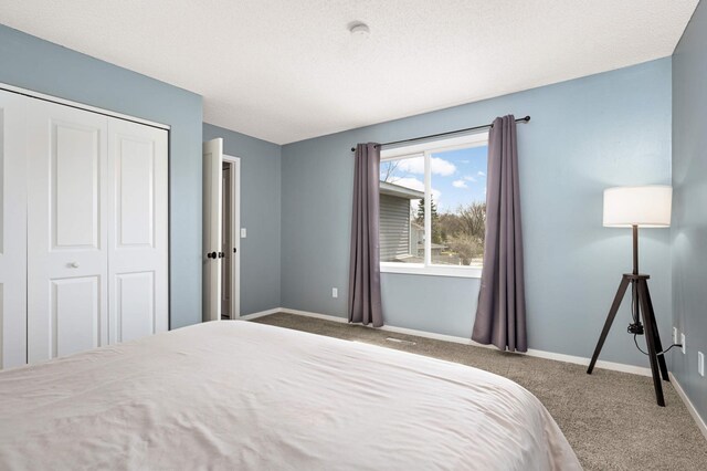 carpeted bedroom featuring baseboards, visible vents, and a closet