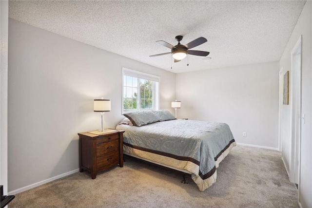 bedroom with a textured ceiling, ceiling fan, light colored carpet, and baseboards