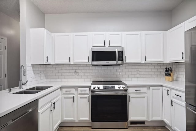 kitchen featuring white cabinetry, a sink, appliances with stainless steel finishes, and light countertops