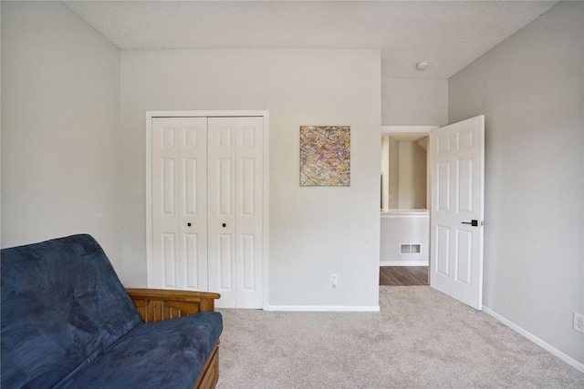 sitting room featuring carpet flooring, a textured ceiling, visible vents, and baseboards