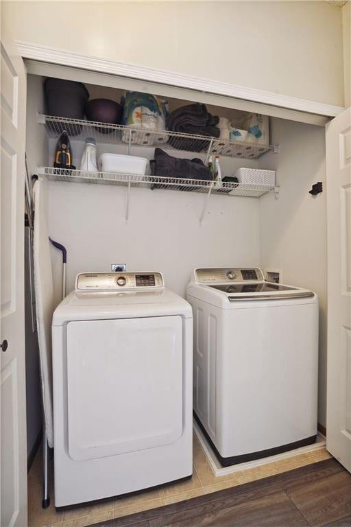 laundry room with light wood-style floors, laundry area, and washing machine and dryer