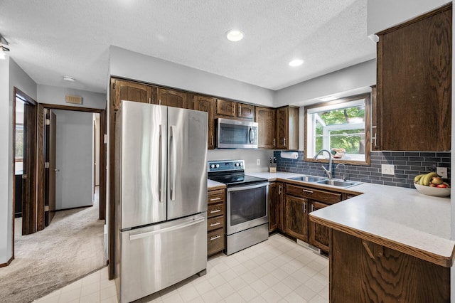 805 Ithaca Ln N, Plymouth, MN 55447 - kitchen with appliances with stainless steel finishes, a sink, dark brown cabinetry, a textured ceiling, and tasteful backsplash