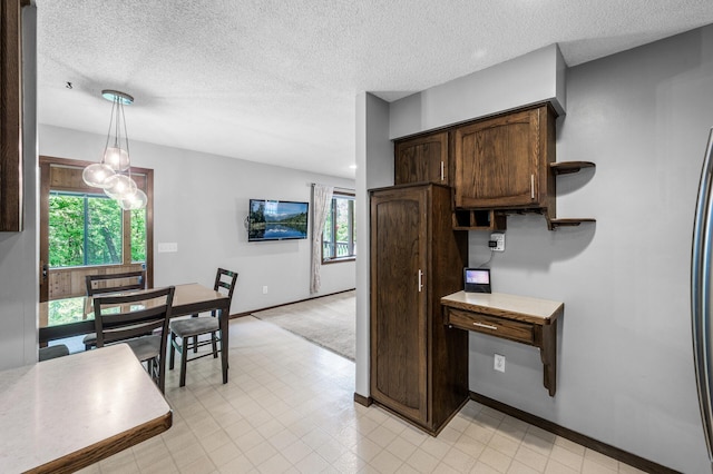 805 Ithaca Ln N, Plymouth, MN 55447 - kitchen featuring dark brown cabinets, a textured ceiling, baseboards, decorative light fixtures, and light countertops