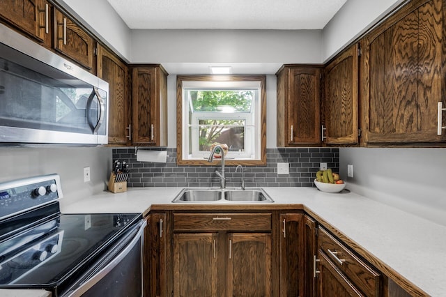 805 Ithaca Ln N, Plymouth, MN 55447 - kitchen featuring stainless steel appliances, a sink, light countertops, tasteful backsplash, and dark brown cabinetry