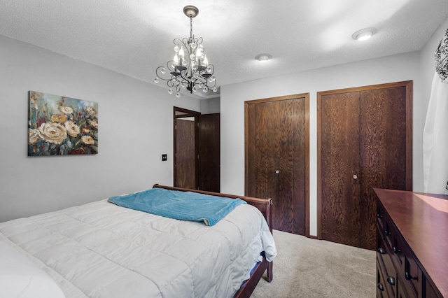 805 Ithaca Ln N, Plymouth, MN 55447 - bedroom with a chandelier, multiple closets, carpet flooring, and a textured ceiling