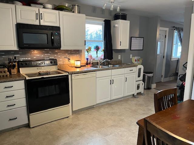 kitchen featuring a sink, white dishwasher, a wealth of natural light, black microwave, and range with electric stovetop