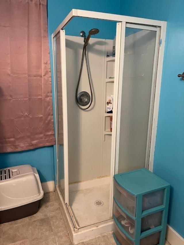 bathroom featuring a stall shower, tile patterned floors, and baseboards