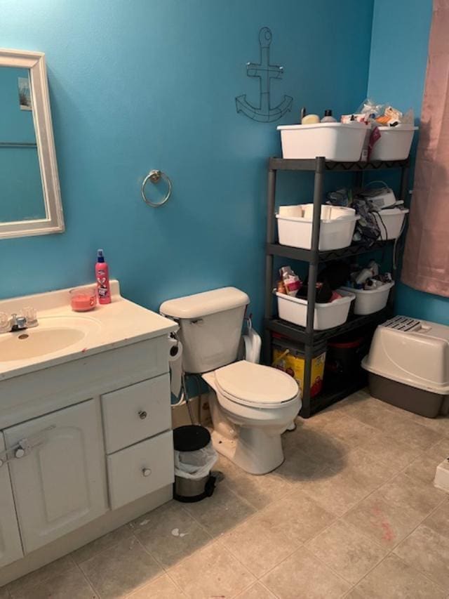 bathroom featuring toilet, tile patterned flooring, and vanity