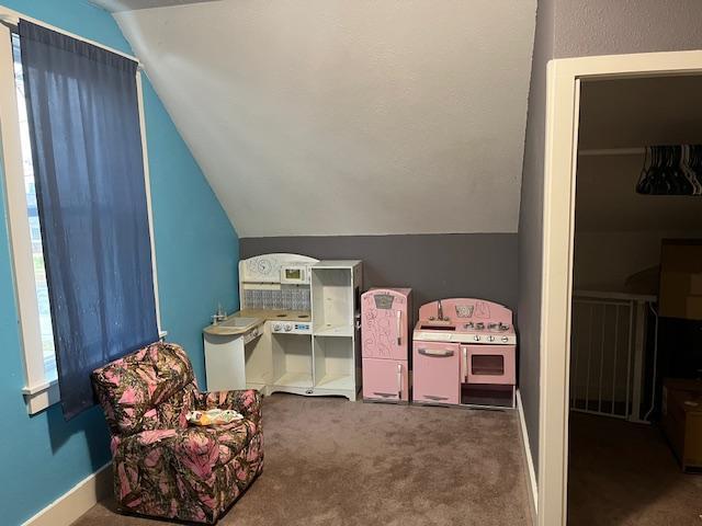 recreation room with carpet, lofted ceiling, and baseboards