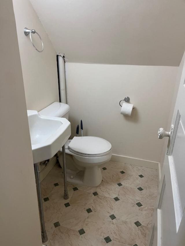 bathroom with toilet and baseboards