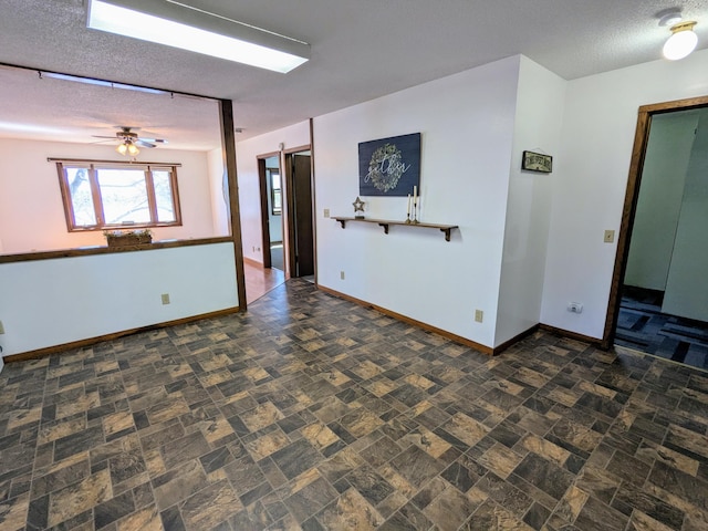 46167 Jefferson Lake Dr, Cleveland Twp, MN 56017 - unfurnished room featuring a textured ceiling, baseboards, stone finish flooring, and a ceiling fan