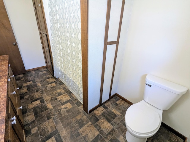 46167 Jefferson Lake Dr, Cleveland Twp, MN 56017 - bathroom featuring toilet, baseboards, and stone finish flooring