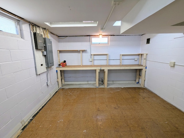 46167 Jefferson Lake Dr, Cleveland Twp, MN 56017 - below grade area with concrete block wall, tile patterned floors, a workshop area, a healthy amount of sunlight, and electric panel
