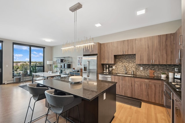 1240 2nd St Unit 526, Minneapolis, MN 55415 - kitchen featuring a sink, tasteful backsplash, a center island, a breakfast bar area, and appliances with stainless steel finishes