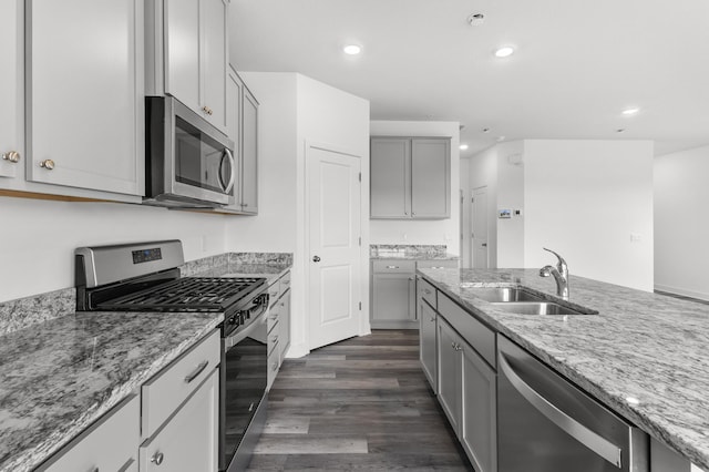 kitchen featuring recessed lighting, gray cabinets, a sink, dark wood-type flooring, and appliances with stainless steel finishes