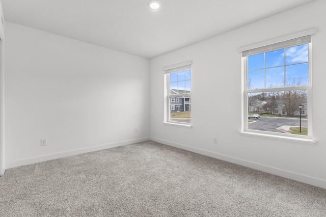 carpeted empty room with baseboards and recessed lighting