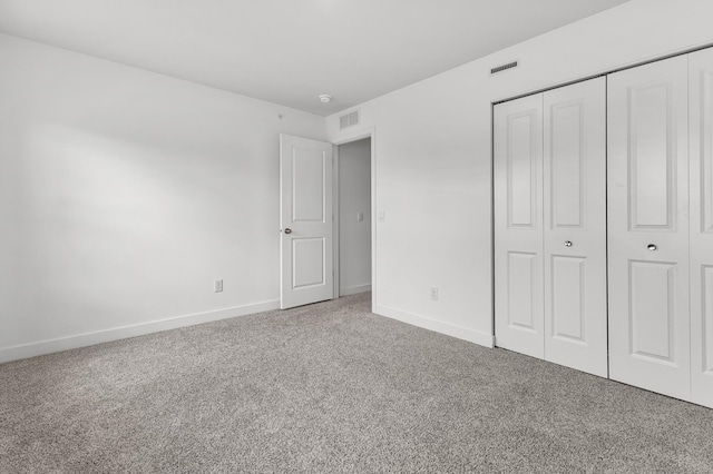 unfurnished bedroom with carpet floors, visible vents, and baseboards