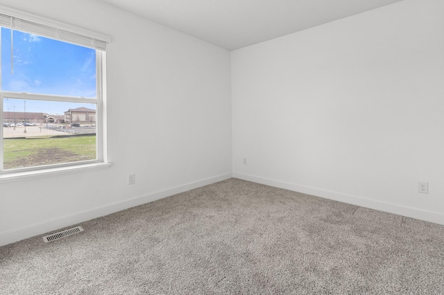 unfurnished room featuring baseboards, carpet flooring, and visible vents