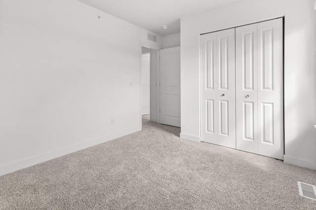 unfurnished bedroom with baseboards, a closet, visible vents, and carpet