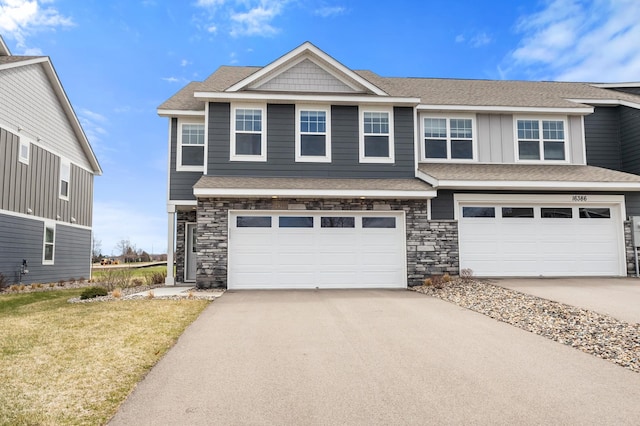 view of front of home featuring concrete driveway, stone siding, and a garage