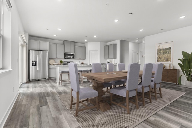 dining area with light wood finished floors, baseboards, and recessed lighting
