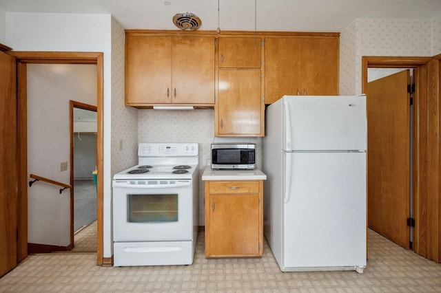 kitchen with brown cabinetry, white appliances, light floors, wallpapered walls, and light countertops