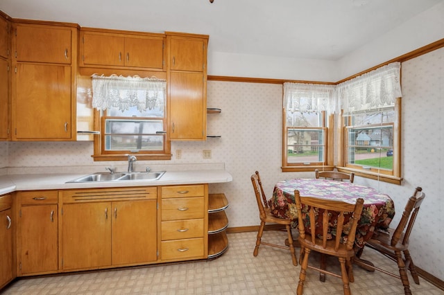 kitchen featuring brown cabinets, open shelves, a sink, light countertops, and light floors
