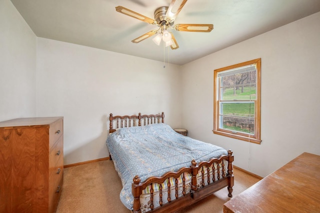bedroom featuring baseboards, light colored carpet, and ceiling fan