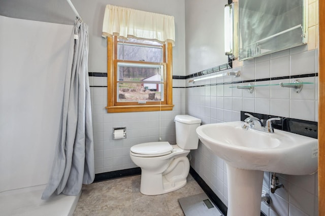 full bath featuring a shower with curtain, toilet, and tile walls