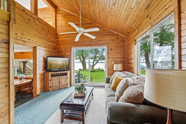 carpeted living room featuring plenty of natural light, vaulted ceiling, and wood walls