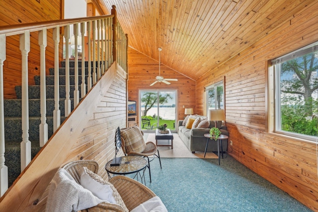 sitting room with a healthy amount of sunlight, wood ceiling, vaulted ceiling, and wood walls