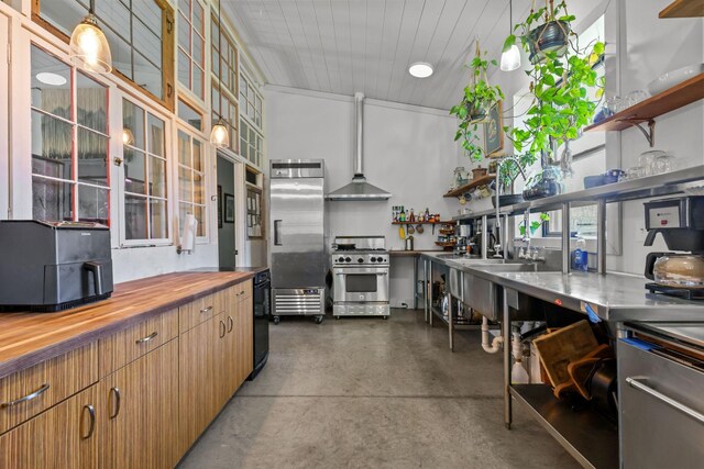 kitchen featuring open shelves, concrete floors, butcher block counters, and premium appliances