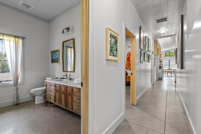 hallway featuring a sink, baseboards, and visible vents
