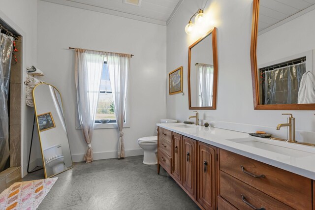 full bathroom with double vanity, toilet, a sink, and finished concrete floors