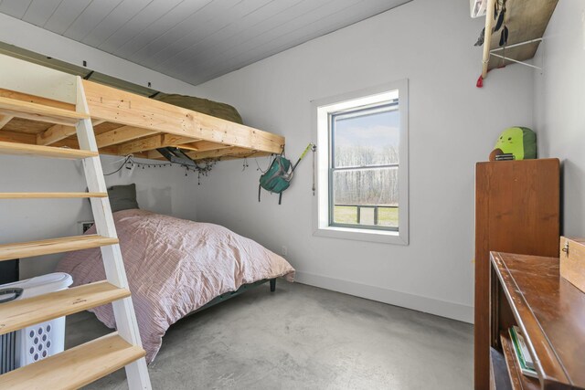 bedroom featuring baseboards and concrete floors