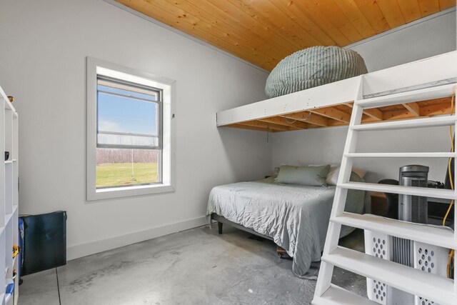 bedroom featuring baseboards, concrete floors, and wood ceiling