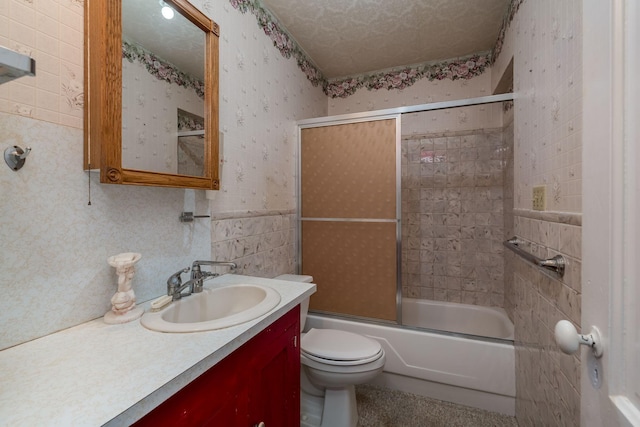 bathroom featuring combined bath / shower with glass door, toilet, vanity, and wallpapered walls