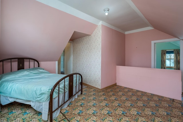 carpeted bedroom with vaulted ceiling and baseboards