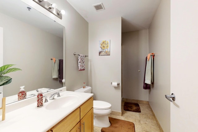 bathroom featuring toilet, vanity, and baseboards