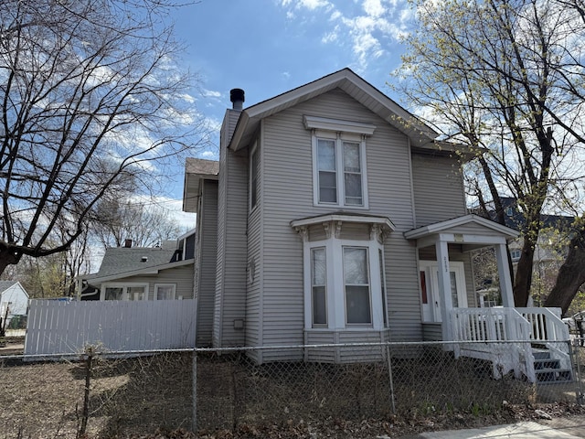 view of front facade with a chimney and a fenced front yard