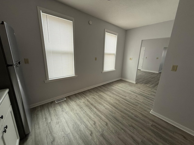 interior space with visible vents, baseboards, and wood finished floors