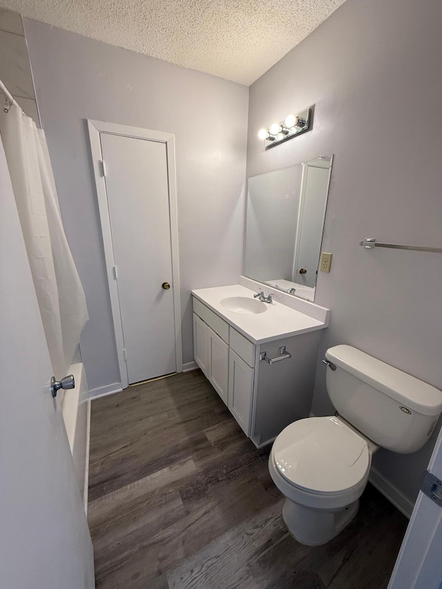 bathroom featuring wood finished floors, a textured ceiling, vanity, and toilet
