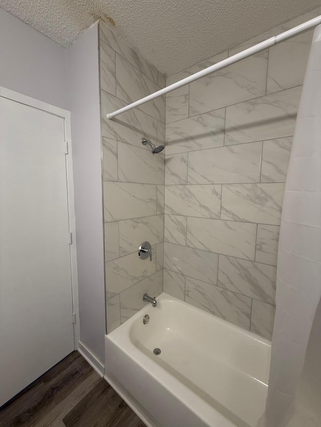 bathroom with wood finished floors, a textured ceiling, and shower / tub combination
