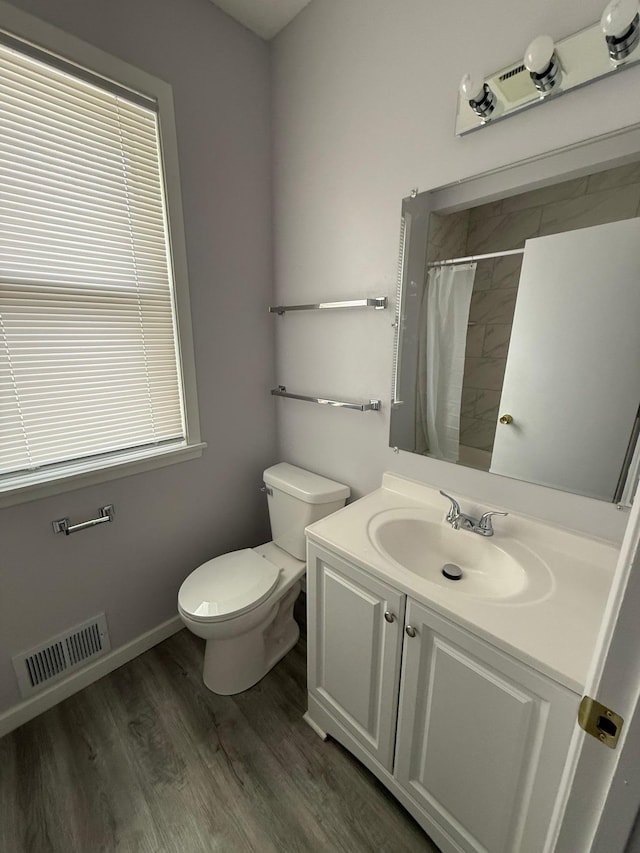 bathroom featuring wood finished floors, visible vents, toilet, vanity, and a shower with curtain