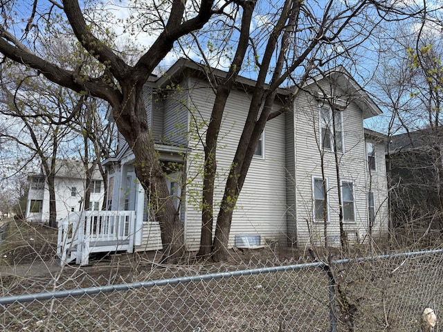 view of side of home featuring fence