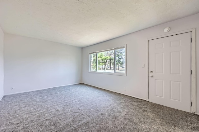 empty room featuring carpet floors and baseboards