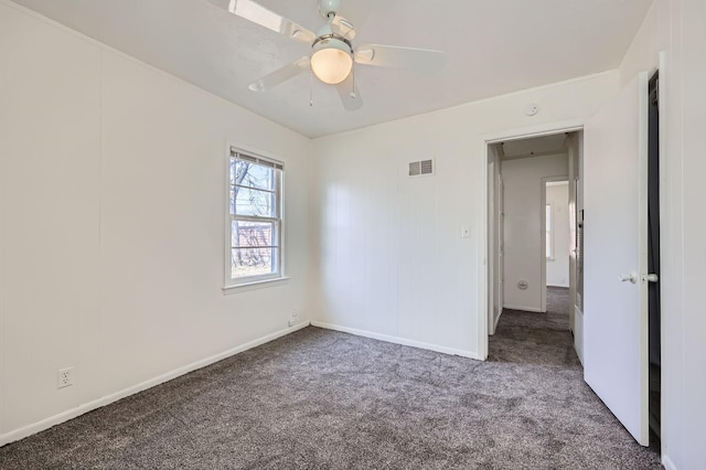 carpeted empty room featuring baseboards, a ceiling fan, and visible vents