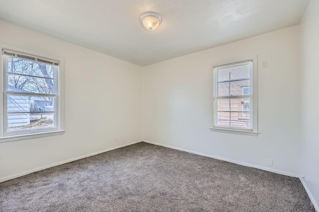 carpeted empty room with baseboards
