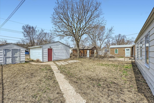 view of yard with fence, an outdoor structure, and a shed