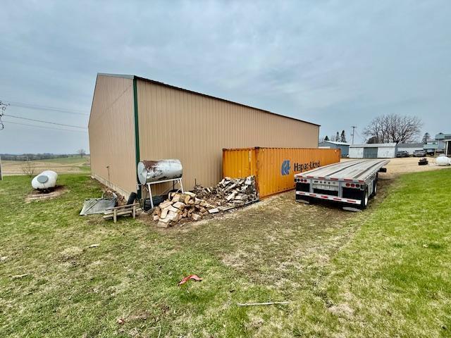 view of property exterior featuring an outdoor structure, an outbuilding, and a yard